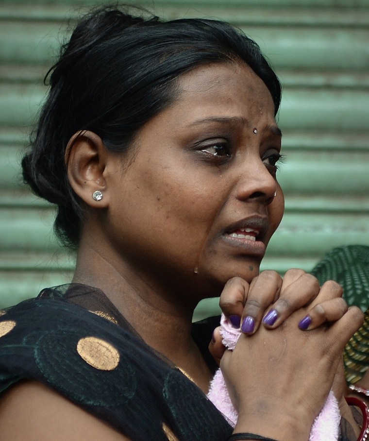 A woman cries as she waits near the site of a building collapse in Mumbai on Sept. 27.