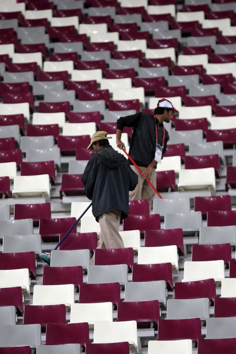 Workers clean the stadium at the end of the 2011 Asian Cup semi-final soccer match between Australia and Uzbekistan in the Qatari capital Doha.