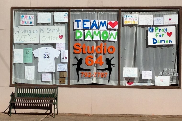 Signs for Damon Janes hang in the window of Studio 64 in Brocton, N.Y. The western New York school district has canceled the remainder of its varsity football season in the aftermath of Janes' death from injuries suffered during a game.