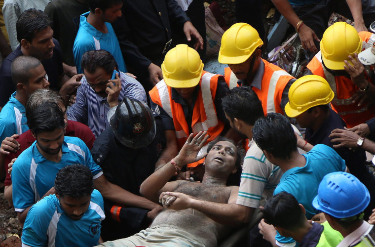 A survivor is rescued from the rubble after a residential building collapsed in Mumbai, Sept. 27.