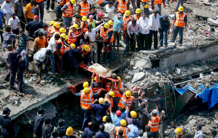 Rescue workers use a stretcher to carry a woman pulled from the rubble at the site of a collapsed residential building in Mumbai, Sept. 27.