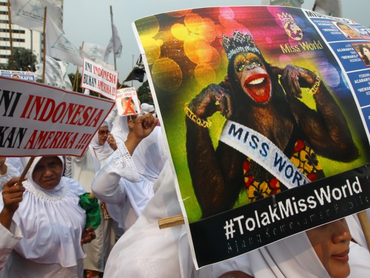 In this Friday, Sept. 6, 2013 photo, Muslim women hold posters reading: Indonesia is not America, left, and Reject Miss World, during a protest demanding the cancellation of the Miss World pageant, in Jakarta, Indonesia.