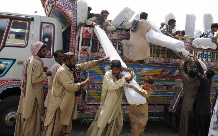 Pakistani earthquake survivors receive tents Saturday at a distribution point in the devastated district of Awaran.