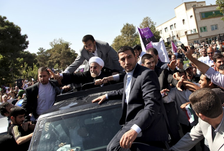 Iranian President Hassan Rouhani, center, waves to supporters Saturday in Tehran upon his return from the U.S.
