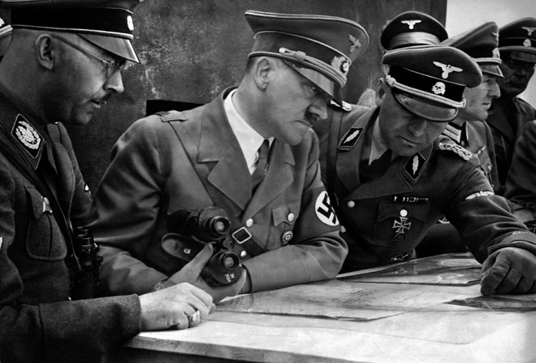 A picture dated 1939 shows dolf Hitler consulting a geographical survey map with his general staff including Heinrich Himmler, left, and Martin Bormann, right.