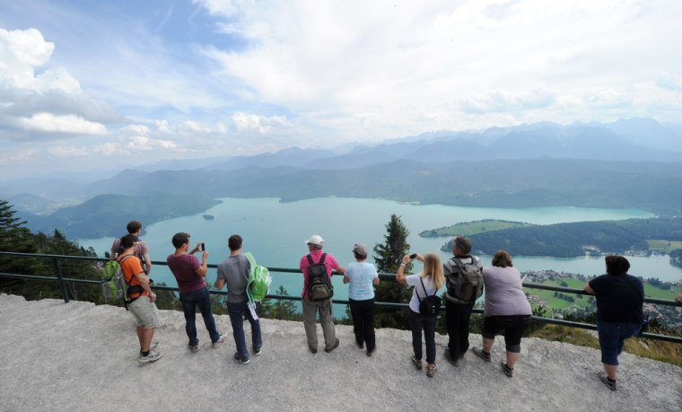 Hikers standing on the Herzogstand mountain look toward Lake Walchensee in the Bavarian foothills of the Alps. The area has become popular with treasures hunters.