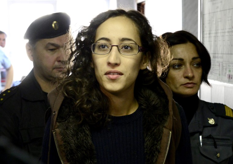 Greenpeace activist Faiza Oulahsen from the Netherlands (front) is escorted at a district court in Murmansk September 29, 2013. A Russian court ordered 20 Greenpeace activists from around the world to be held in custody for two months pending further investigation over a protest against offshore oil drilling in the Arctic, drawing condemnation and a vow to appeal.