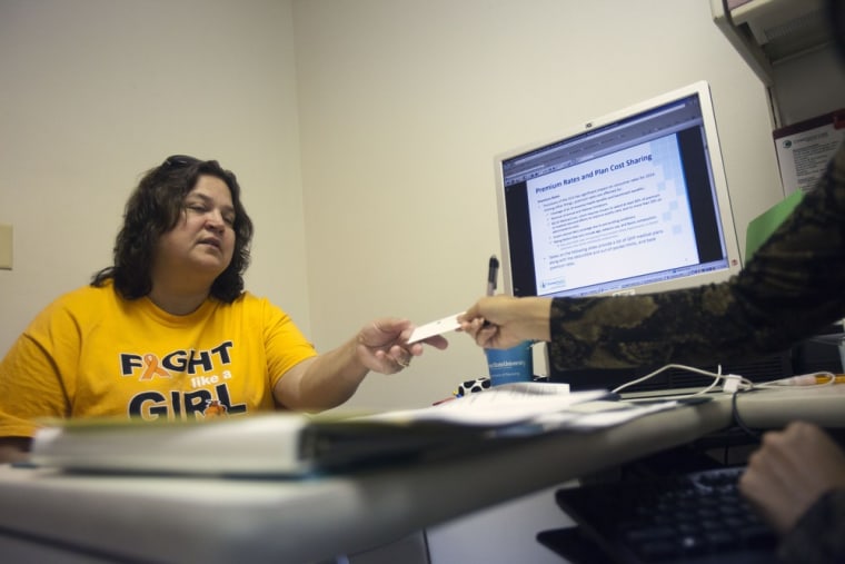 Wanda Perry, 48, is counseled by a marketplace guide about her options regarding the Health Insurance Marketplace. The new exchanges, a centerpiece of health reform, go live Tuesday.