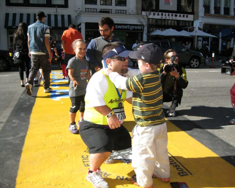 Young with his son Owen at the finish line of the Boston Marathon last year, two weeks after the bombing stopped the race.