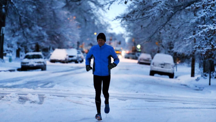 Image: A man jogs on a street freshly covered in snow on Jan. 31, 2014, in Boulder, Colo.