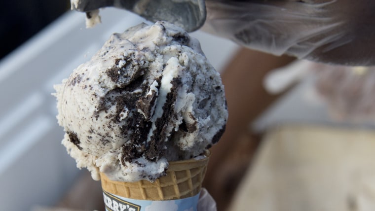 An employee of Ben & Jerry's scoops ice cream into a cone