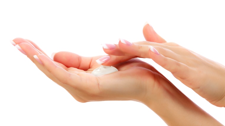 Female hands with a moisturizer cream on white background