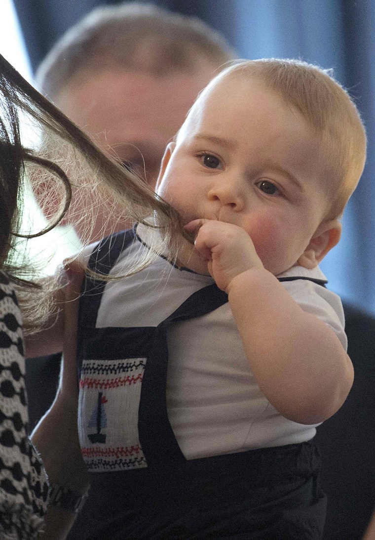 Britain's Prince George is seen with some of his mother Catherine, The Duchess of Cambridge's hair in his mouth, as she holds him during a Plunket nur...