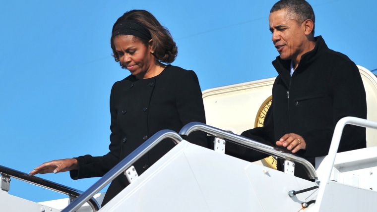 US President Barack Obama and First Lady Michelle Obama step off Air Force One upon arrival at Andrews Air Force Base in Maryland on March 9, 2014. Ob...