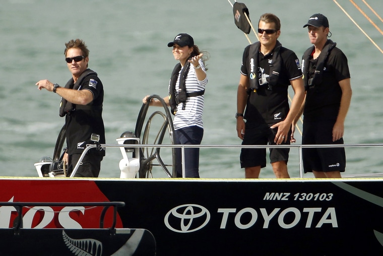 Catherine (2nd L), the Duchess of Cambridge, gestures as she steers an America's Cup yacht towards her husband, Britain's Prince William, after she cr...