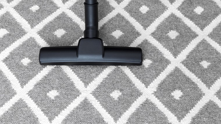 Housework. Vacuum cleaner on gray carpet.