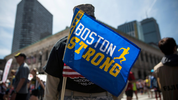 Image: A solider with a Boston Strong flag supports the runners at the 2014 Boston Marathon