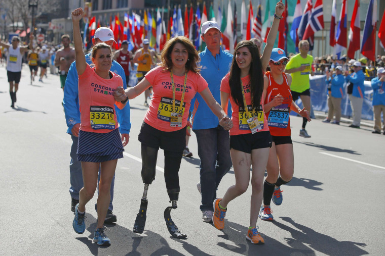 2013 Boston Marathon survivors Celeste Corcoran (C) and her daughter Sydney (R) finish the race with Celeste's sister Carmen Acabbo, who ran the 118th Boston Marathon, in Boston, Massachusetts April 21, 2014.