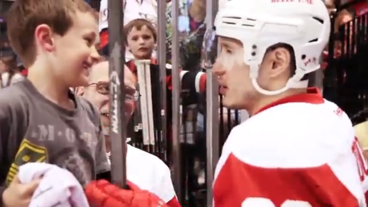 Canadian hockey player Jordin Tootoo gives his stick to a young fan