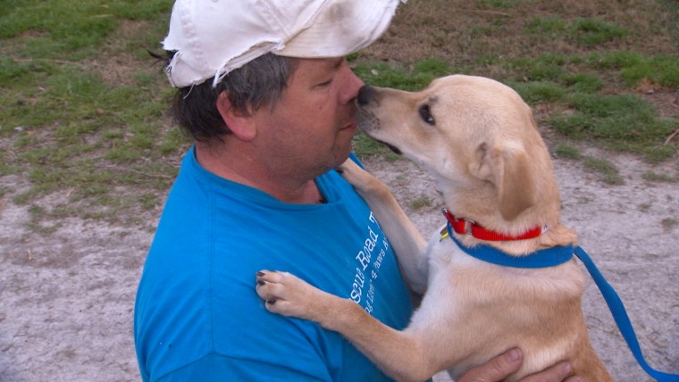 Greg Mahle with one of his rescued pups.