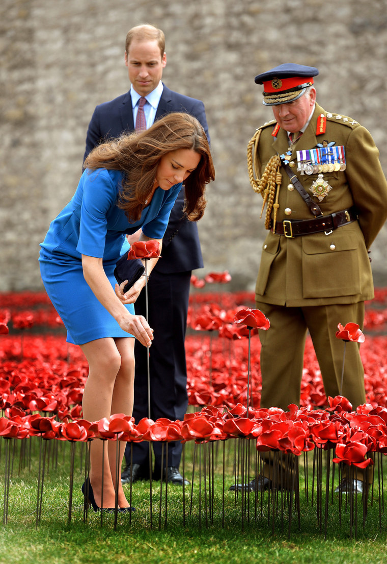 LONDON, UNITED KINGDOM - AUGUST 05:  Catherine, The Duchess of Cambridge adds a ceramic poppy watched by Prince William, Duke of Cambridge and Lord Da...