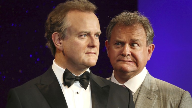 British actor Hugh Bonneville, right, who plays "Downtown Abbey's" Lord Grantham, looks at his wax figure at Madame Tussauds