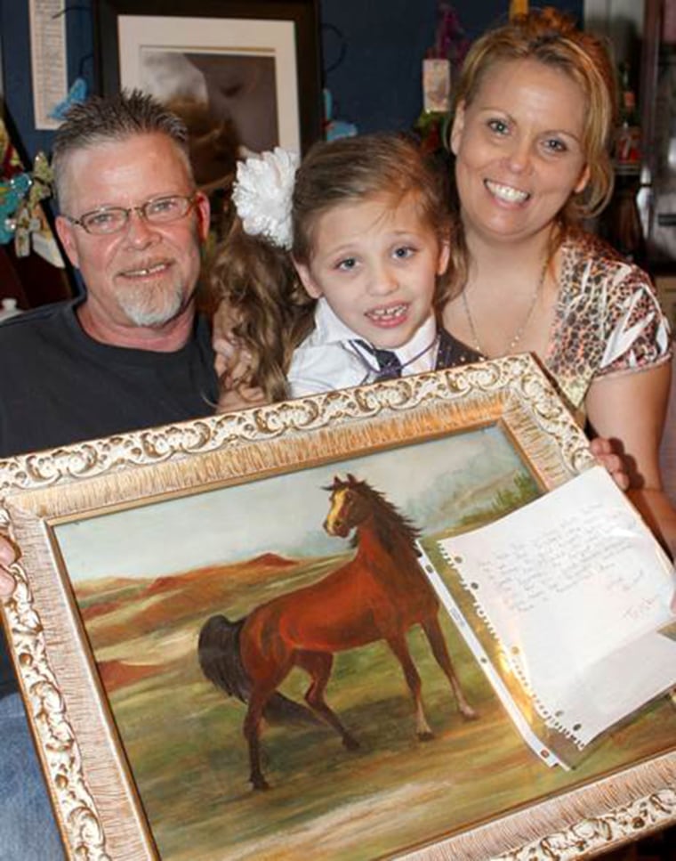 Alexus with her parents and one of the horse pictures she's received; she has no idea she's about to get a horse of her very own.
