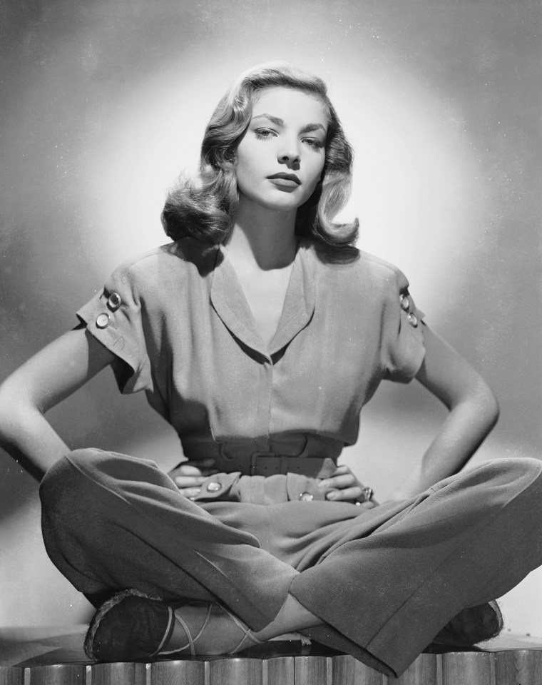 circa 1945:  American screen star Lauren Bacall sitting cross-legged in a trouser suit, with her hands on her hips.  (Photo via John Kobal Foundation/...