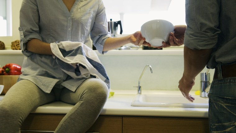 Couple washing dishes together (PhotoAlto via AP Images)