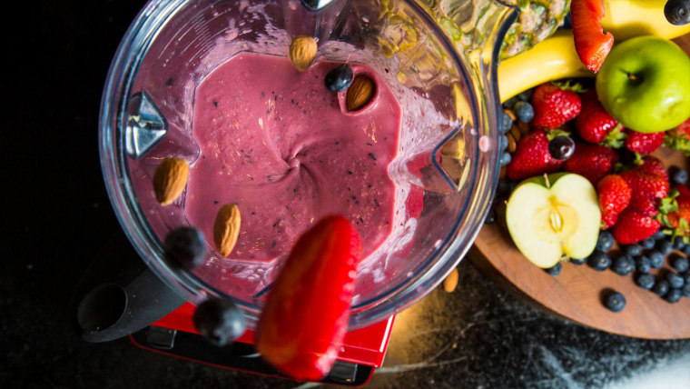 Strawberries, bananas, blueberries and almonds combine in a blender for a smoothie.