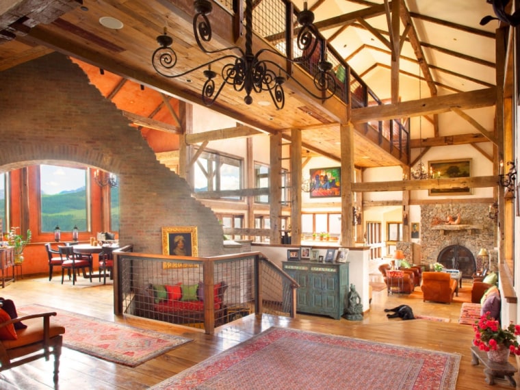 The home's design includes brick fireplaces, beamed ceilings and log-cabin walls.