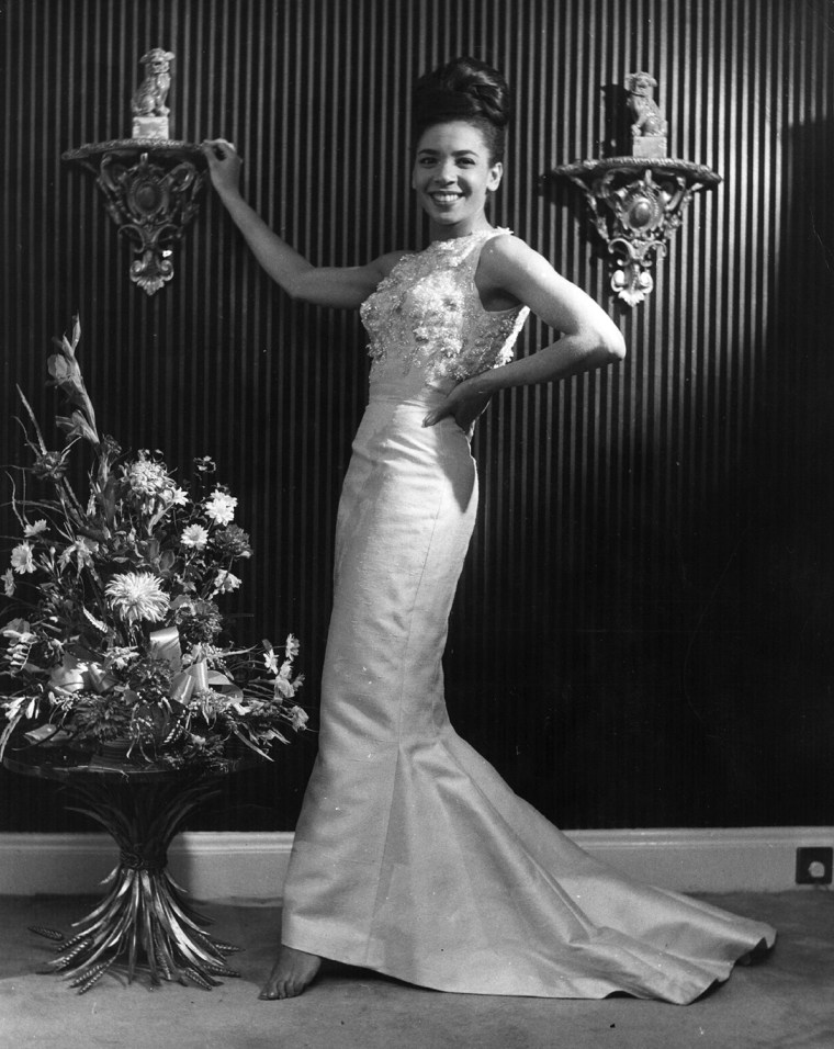 December 1962:  Popular Welsh singer Shirley Bassey tries on another dress during her quest for what to wear to the White House, where she has been as...