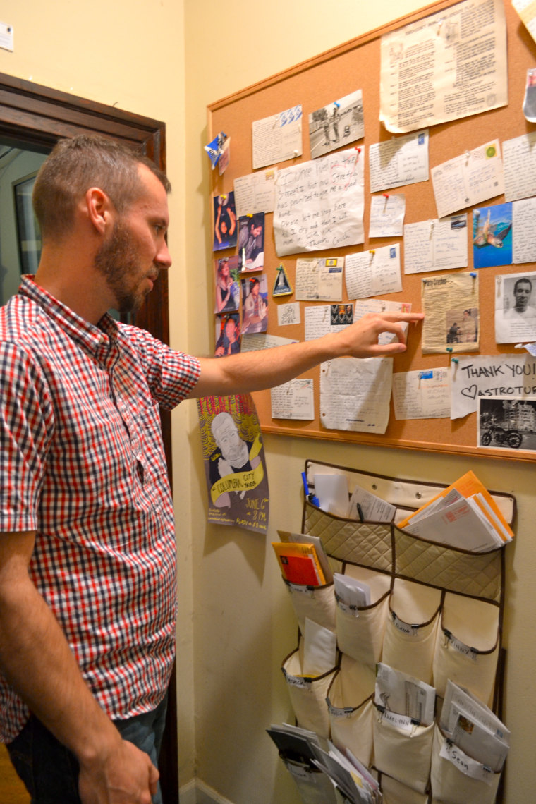 Sean Gibbons, 28, checks out the communal bulletin board at his shared rental in Seattle. So many people are interested in living there that the group has an occasional “open house” to select new roommates from among applicants.