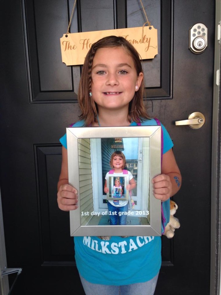 Starting 2nd grade by holding a pic of what she looked like starting 1st grade.