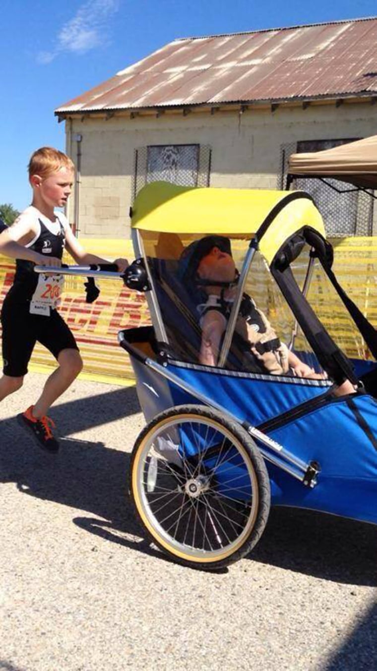 Noah Aldrich pushes his little brother Lucas during a youth triathlon in Boise, Idaho.