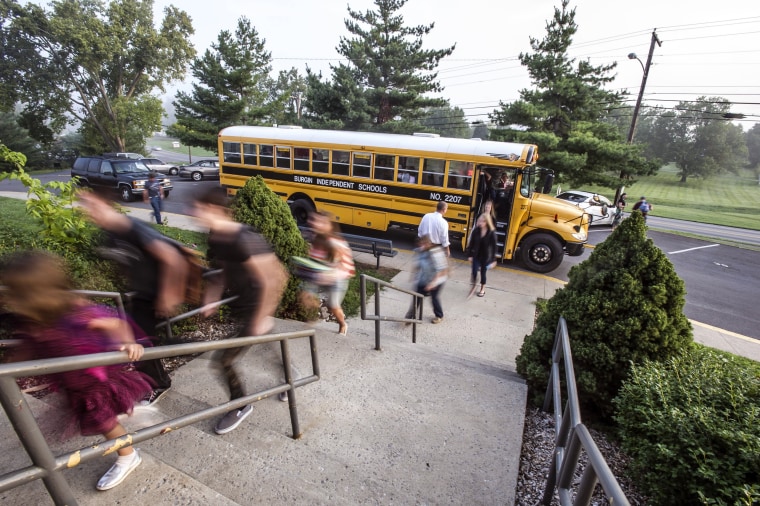 Students get off the bus and head  into school Monday, Aug. 4, 2014, during the first day of school at Burgin Independent School in Burgin, Ky.
