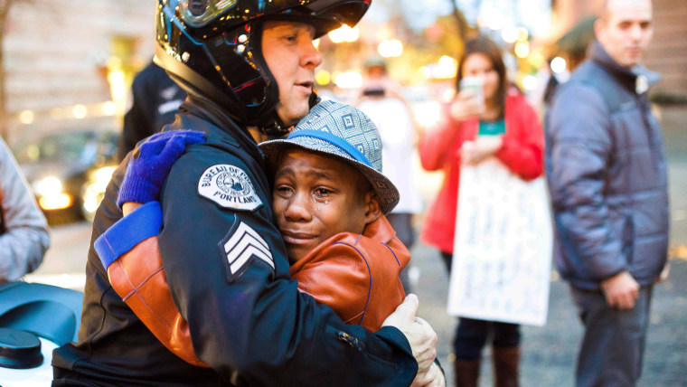 Portland police Sgt. Bret Barnum, left, and Devonte Hart, 12, hug at a Ferguson protest rally in Portland, Oregon, on Nov. 25.