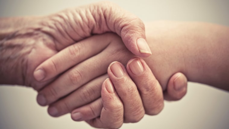 Elderly hand and caregiver