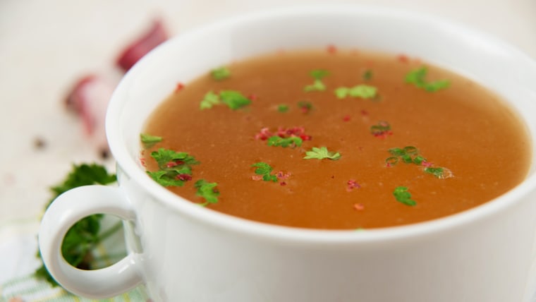 Bone Broth in Small Soup Bowl Served with Fresh Herbs, Garlic and Spices; Shutterstock ID 144087859; PO: TODAY.com