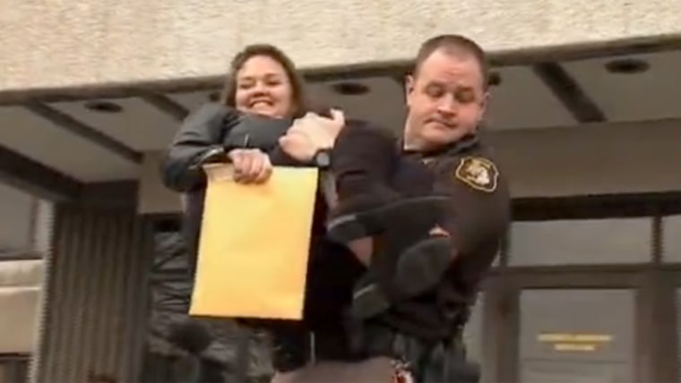 Michigan woman Kristi Earley, who has multiple sclerosis, gets an assist from Mark Bennett of the Wayne County Sheriff's Department to help get to her car after a power outage at a building in Detroit.