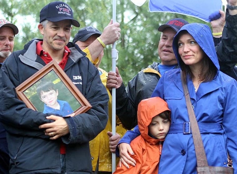 Moving forward, together: Holding a picture of his youngest son Dylan, Ian Hockley stands with his wife Nicole and their oldest son Jake at a recent community gathering.