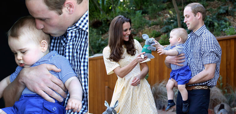 Prince William kisses Prince George as they look at an Australian animal called a Bilby.