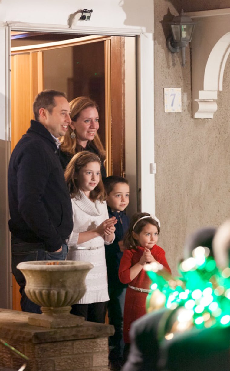 The Schreiber family reacts to the carolers on the front lawn. Only the mother, Lauren Schreiber, knew that a fun surprise was going to happen, but di...