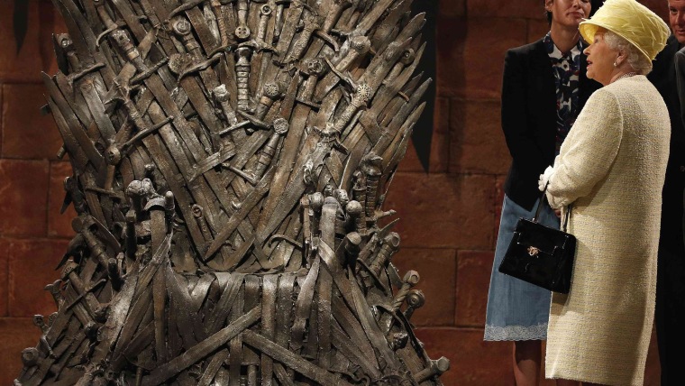 Britain's Queen Elizabeth looks at the Iron Throne as she meets members of the cast on the set of \"Game of Thrones.\"