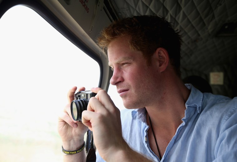 MOKHOTLONG, LESOTHO - DECEMBER 08:  Prince Harry takes a photograph out of the window of a Lesotho Army Helicopter on a Fuji X100s Camera as he travel...