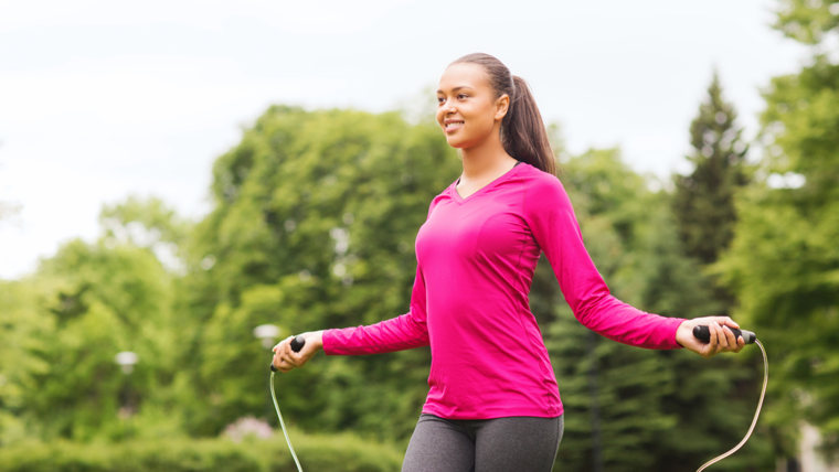 fitness, sport, training, park and lifestyle concept - smiling african american woman exercising with jump-rope outdoors; Shutterstock ID 206547886; P...