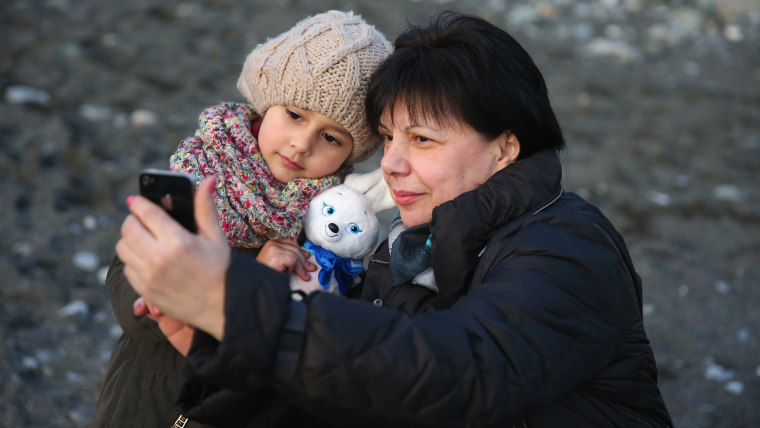 SOCHI, RUSSIA - FEBRUARY 02:  A family takes pictures with Olympic mascot at the beach of Sochi sea port on February 2, 2014 in Sochi, Russia.  (Photo...