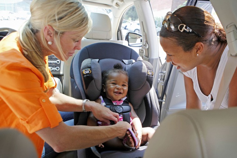 Child Safety Expert Kimberlee Mitchell, left, installs a car seat for Kennedy Word, 8 months, as mother Kimberly St. Louis looks on during a car seat ...