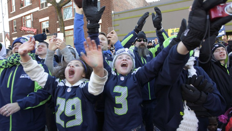 Fans wave as they line the parade route for the Seattle Seahawks Super Bowl XLVIII championship in Seattle, Wednesday, Feb. 5, 2014. The Seahawks defe...