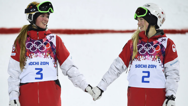 Second-placed Chloe Dufour-Lapointe (L) of Canada and her sister, first-placed Justine Dufour-Lapointe (R), hold hands during the flower ceremony for ...